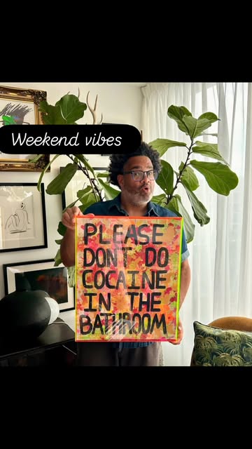 Luis holding Please Don't Do Cocaine in the Bathroom